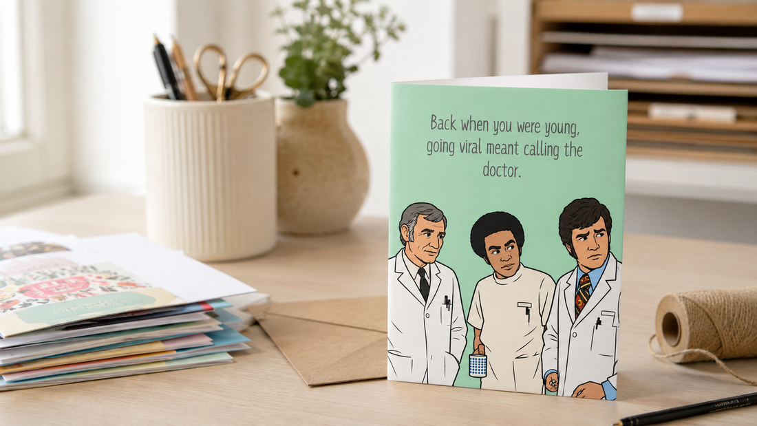 Funny greeting card designed and printed in Alberta displayed in a home studio with envelopes, stationery, and packaging supplies.