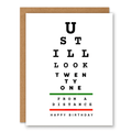 You Still Look 21 (From a Distance) Birthday Card showing eye-chart-style typography with a green and red vision-chart line with front cover text: U still look twenty one from a distance. Happy birthday