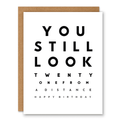 You Still Look 21 Birthday Card showing bold eye-chart-style typography with a small red heart with front cover text: You still look twenty one from a distance. Happy birthday