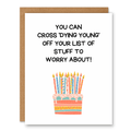 Cross ‘Dying Young’ Off Your List Birthday Card showing a birthday cake with candles and darkly funny aging text with front cover text: You can cross ‘dying young’ off your list of stuff to worry about!