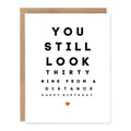 Funny 40th Birthday Card Still Look 39 showing bold eye-chart-inspired black typography with a tiny red heart with front cover text: You still look thirty nine from a distance. Happy birthday