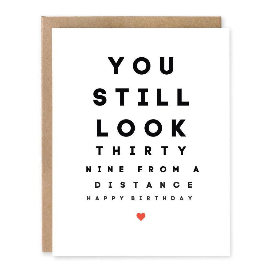 Funny 40th Birthday Card Still Look 39 showing bold eye-chart-inspired black typography with a tiny red heart with front cover text: You still look thirty nine from a distance. Happy birthday