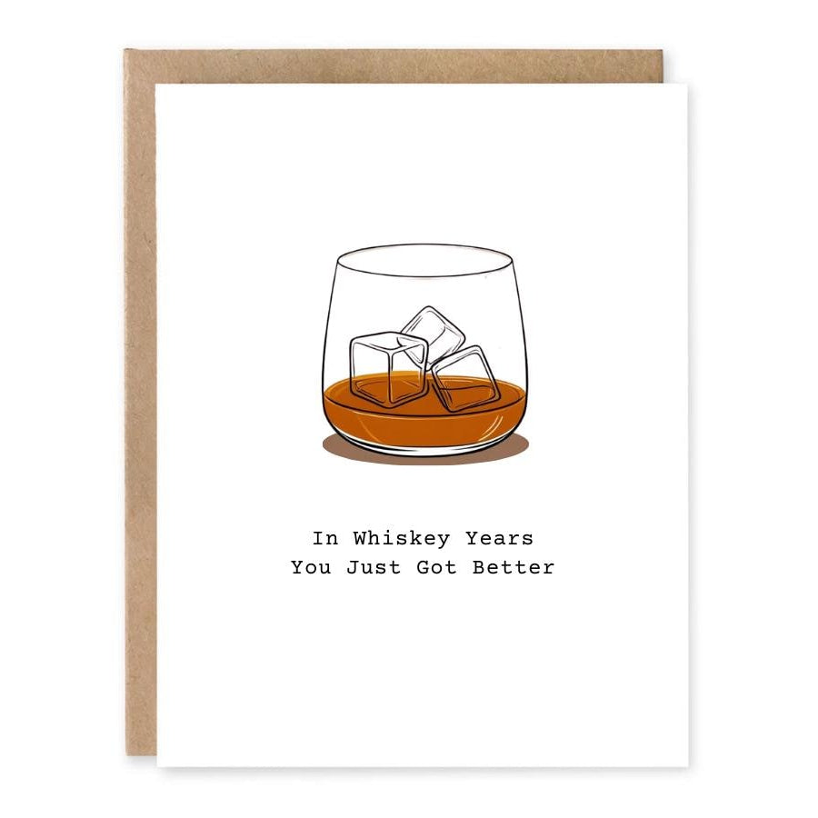 Whiskey Birthday Card for Him showing a glass of whiskey with ice on a clean minimal card front with front cover text: In whiskey years you just got better