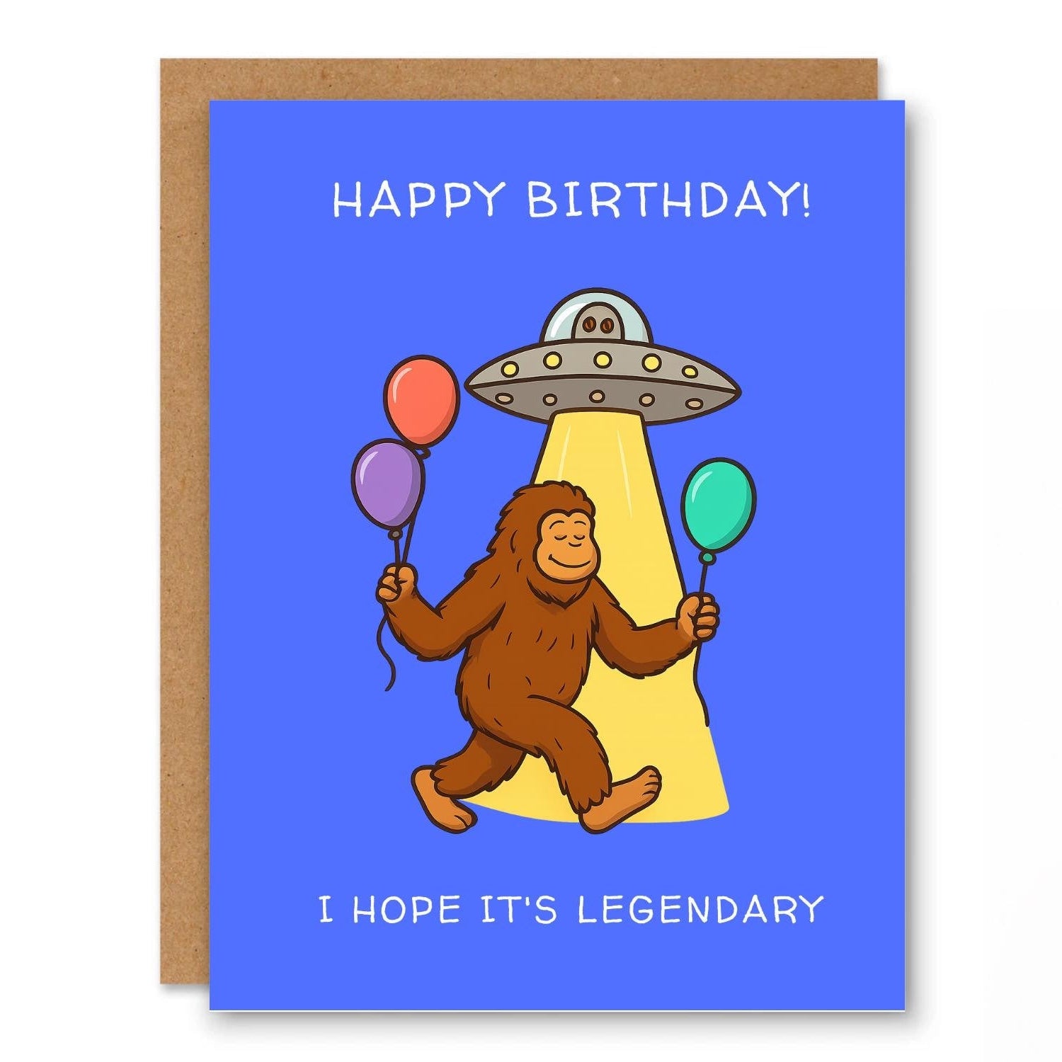 Bigfoot UFO Birthday Card Legendary showing Bigfoot holding balloons under a UFO beam of light with front cover text: Happy Birthday! I hope it’s legendary